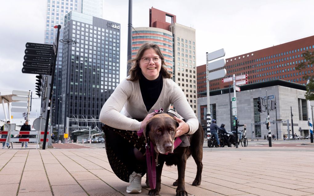 Diana de Wit met haar hulphond Segra in het centrum van Rotterdam, vlak bij haar werk bij de rechtbank. Dankzij de hulphond kan Diana rustig blijven in stressvolle situaties. beeld Dirk Hol 