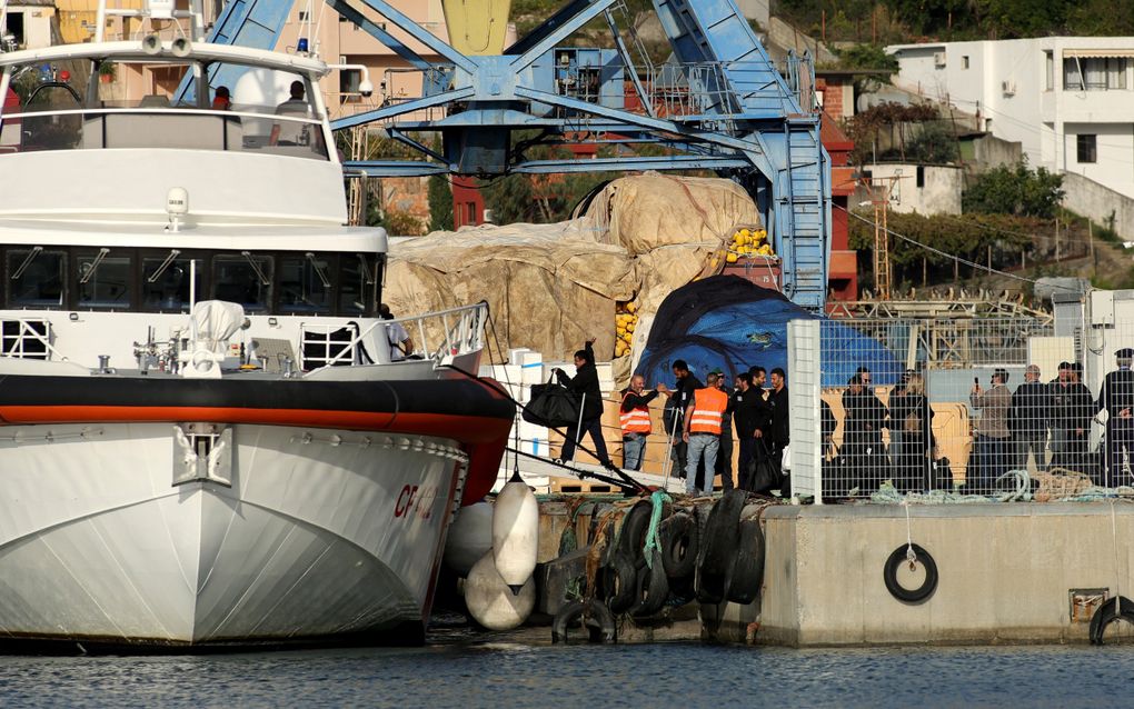 Een groep migranten gaat aan boord van een Italiaans kustwachtschip in de haven van Shëngjin in Albanië. beeld AFP, Adnan Beci 