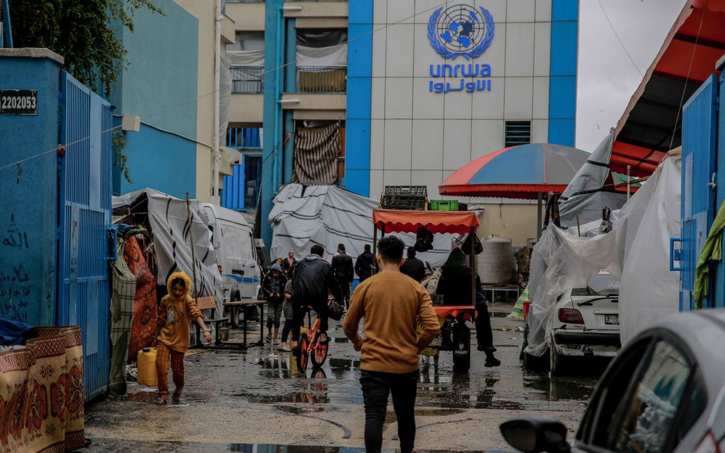 Palestijnen lopen bij de ingang van een UNWRA school in Gaza. beeld AFP, Omar El-Qattaa 