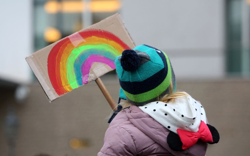 Een jonge demonstrante houdt een bord met een regenboog vast tijdens een demonstratie in Berlijn. beeld AFP, Adam Berry 