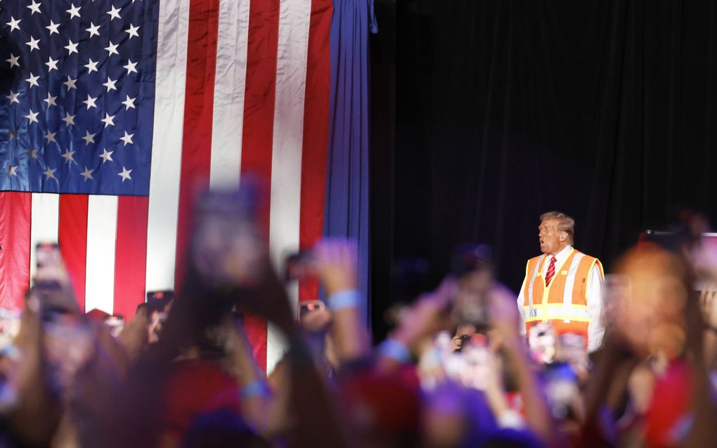 Presidentskandidaat Donald Trump houdt woensdag een campagnebijeenkomst in de staat Wisconsin gekleed in de outfit van een vuilnisman. beeld EPA, Jeffery Phelps