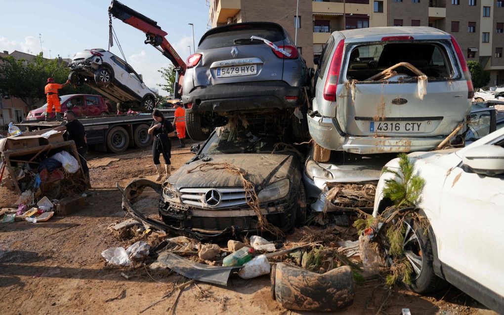 De opwarming van de aarde zorgde in Spanje vorige week voor extra zware neerslag en dito overstromingen. Foto: verwoeste auto’s worden weggetakeld in Massanassa bij Valencia. beeld AFP, Cesar Manso