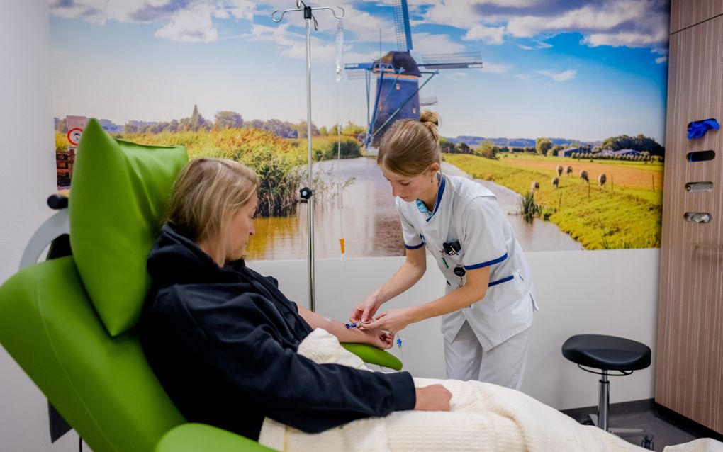 Een medewerker helpt een patiënt op de afdeling oncologie van het Haaglanden Medisch Centrum Antoniushove. beeld ANP, Marco de Swart