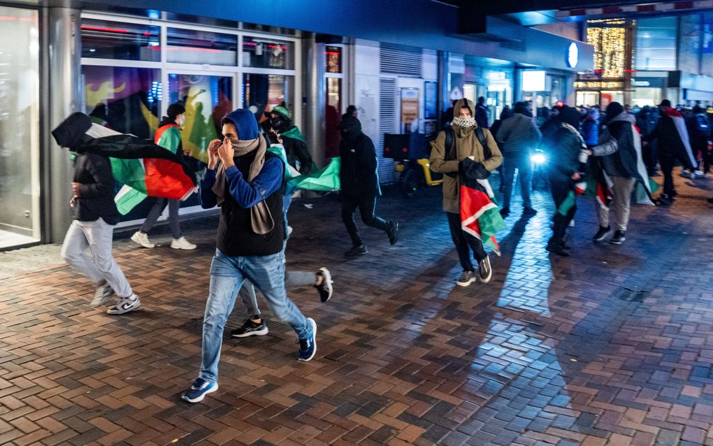 Demonstranten rennen met Palestijnse vlaggen, donderdag in Amsterdam. beeld ANP, Jeroen Jumelet