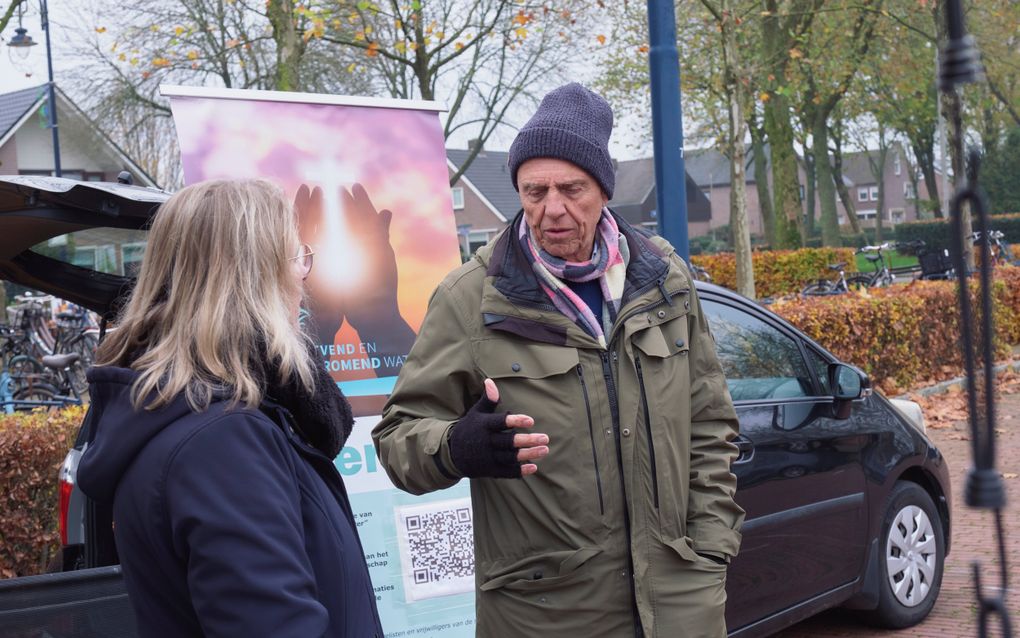 Evangelist Cees van Beek in gesprek met een bezoeker van de markt in Staphorst. beeld Sjaak Verboom