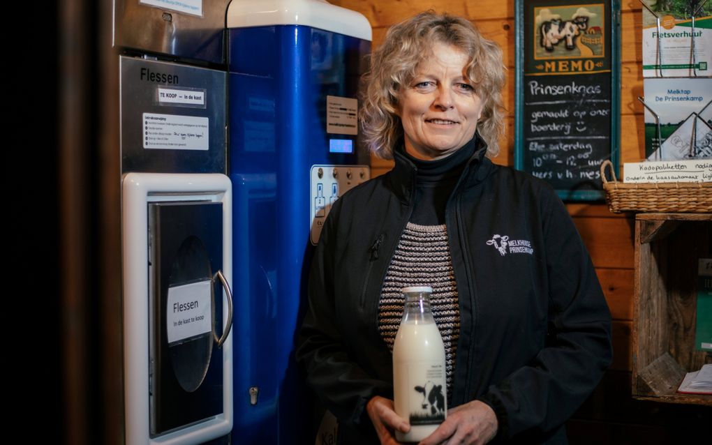 Boerin Corry Kok met in haar hand een fles van de eigen melk en melktap. beeld Tijmen Berens