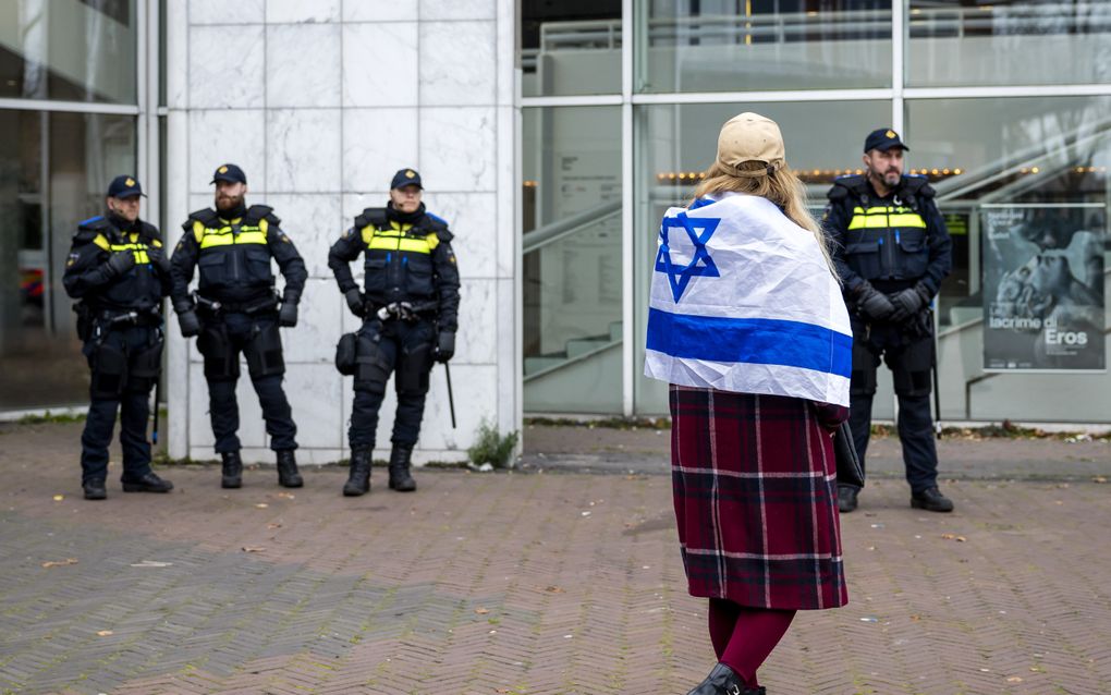 Een vrouw met de vlag van Israël op haar rug, eerder deze maand voor de Stopera in Amsterdam, na geweld tegen Israëliërs. beeld ANP, Remko de Waal