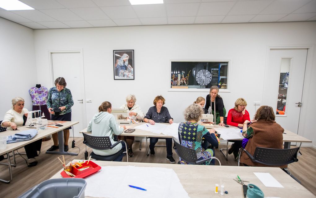 Naailes met een missie bij kringloopwinkel en activiteitencentrum Bij de Tijd in Emmen onder leiding van Anita de Vos (staand rechts). beeld Huisman Media