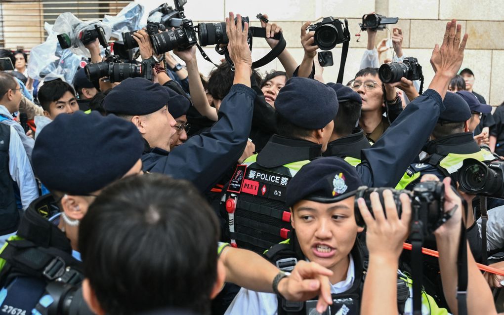 De politie weerhoudt dinsdag de media ervan foto’s te maken van het West Kowloon Magistrates' Court in Hongkong. beeld AFP, Peter Parks