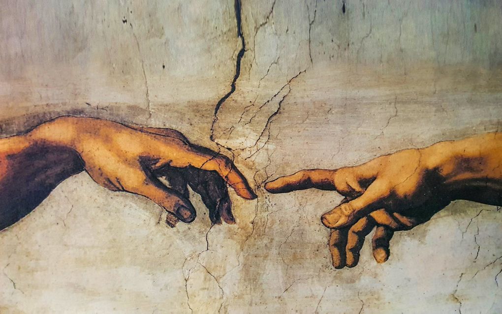 Fragment uit ”De schepping van Adam” van Michelangelo, een fresco dat werd geschilderd rond 1511. beeld iStock