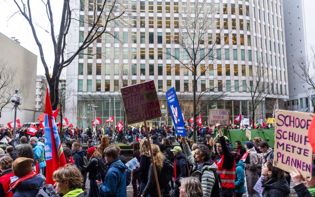 Deelnemers aan een protest tegen de bezuinigingsplannen van het kabinet op onderwijs en onderzoek lopen voor het ministerie van Onderwijs, Cultuur en Wetenschap. beeld ANP, Jeroen Jumelet