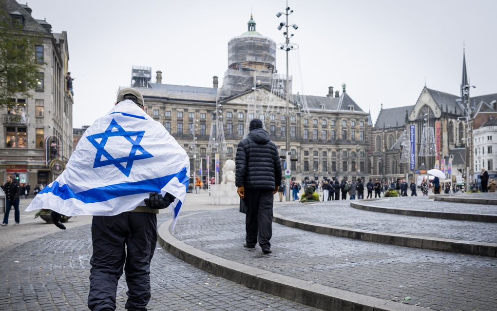 Een man met een Israëlische vlag op de Dam in Amsterdam, daags na aanvallen op Israëlische voetbalsupporters op 8 en 9 november. beeld ANP, Remko de Waal