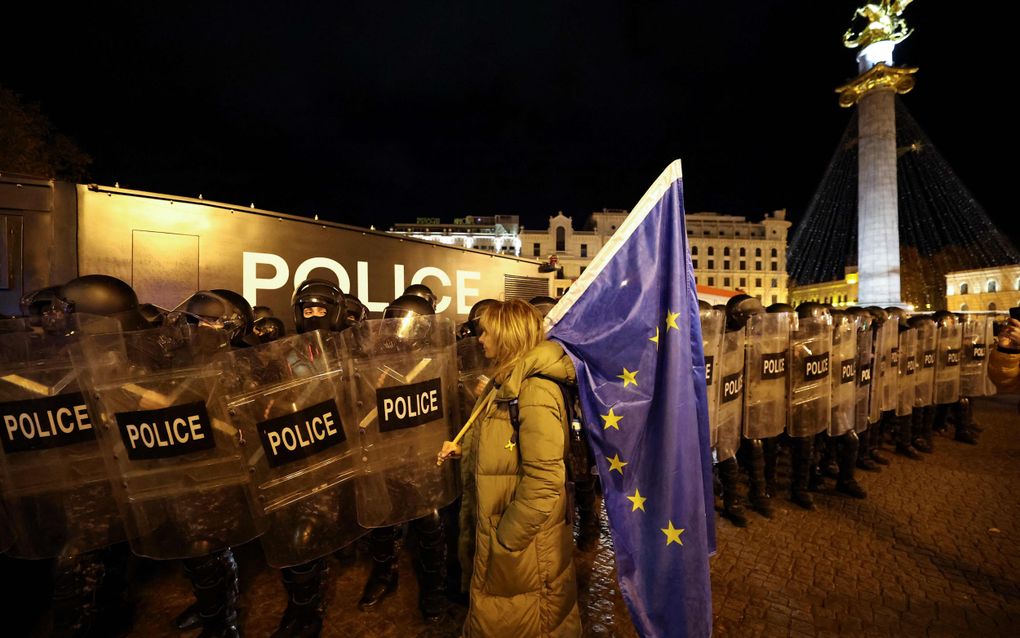 Een vrouw in de Georgische hoofdstad Tbilisi staat donderdag met een EU-vlag voor de oproerpolitie. beeld Giorgi Arjevanidze