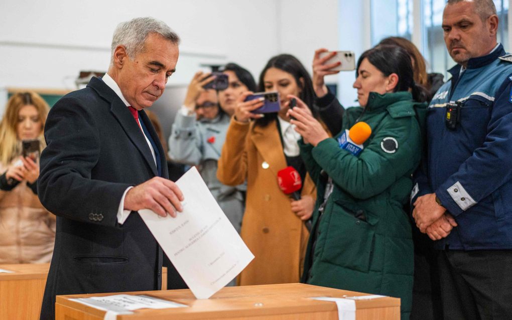 Calin Georgescu, de winnaar van de eerste ronde van de Roemeense presidentsverkiezingen, brengt zondag zijn stem uit voor de parlementsverkiezingen. beeld AFP, Mihai Barbu