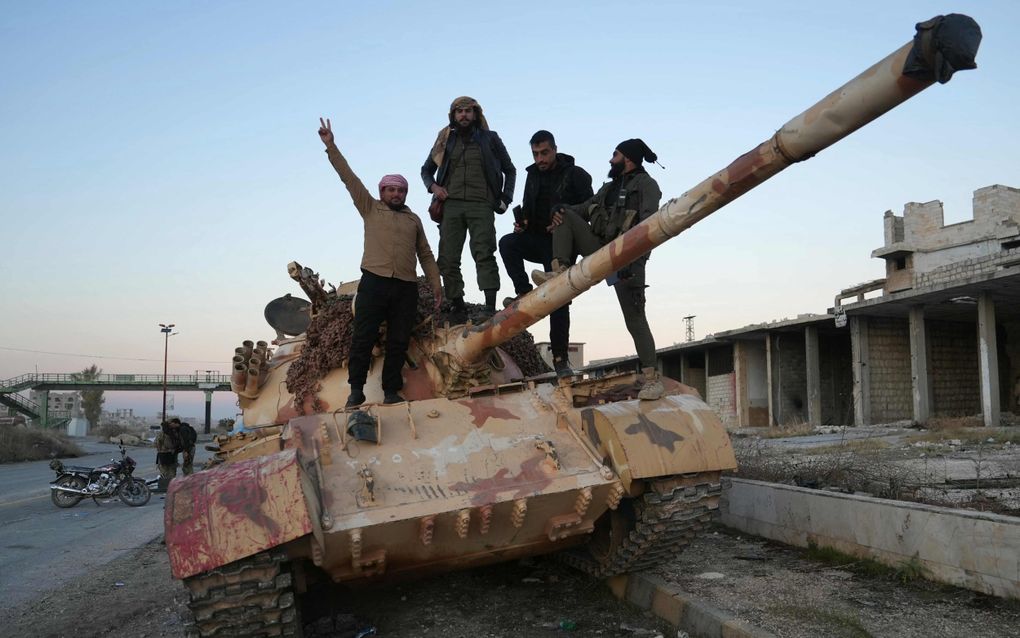 Rebellen poseren zaterdag op een buitgemaakte tank in het noordwesten van Syrië. beeld AFP, Muhammad Haj Kadour