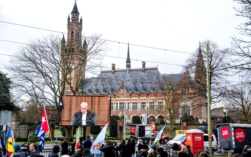 Klimaatactivisten met vlaggen van eilandstaten bij het Internationaal Gerechtshof in Den Haag. Maandag startte een reeks hoorzittingen over een klimaatzaak die door eilandengroep Vanuatu is gestart. beeld ANP, Lina Selg