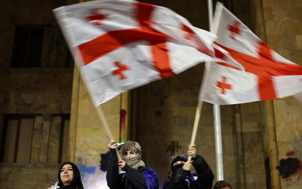 Demonstranten zwaaien in de nacht van maandag op dinsdag met Georgische vlaggen in de hoofdstad Tbilisi. beeld AFP, Giorgi Arjevanidze