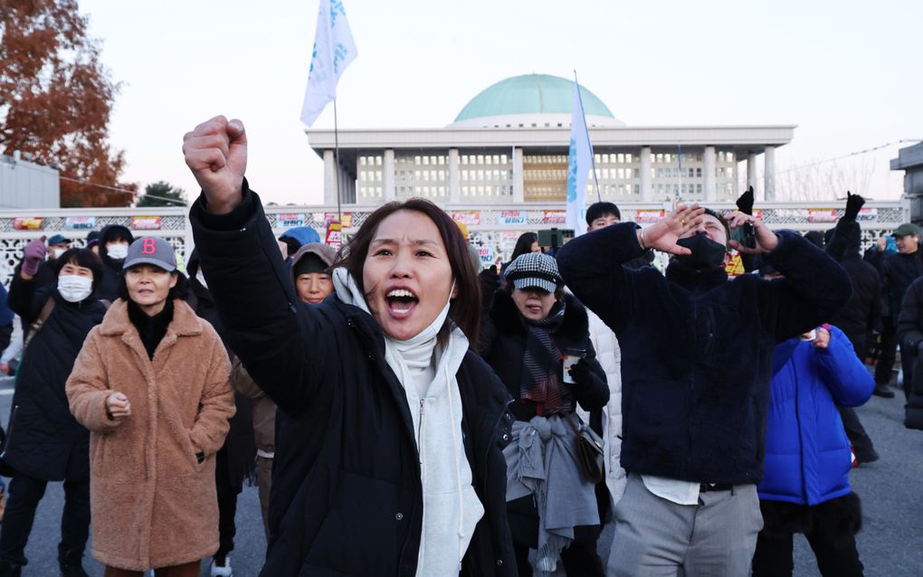 Demonstranten buiten het parlement in Seoul roepen op tot het aftreden en de afzetting van de Zuid-Koreaanse president Yoon Suk-yeol. beeld EPA, Han Myung-Gu