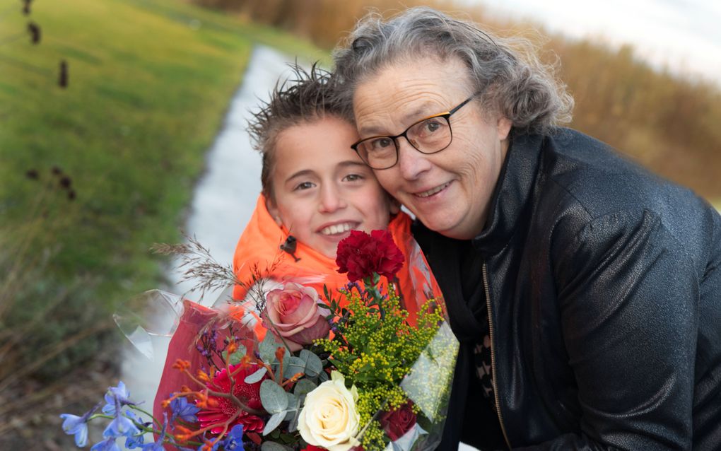 De zevenjarige Cees van Aalsburg geeft oma Visser een bloemetje. „Doordat oma woorden met mij oefent, gaat het lezen steeds beter.” beeld William Hoogteyling