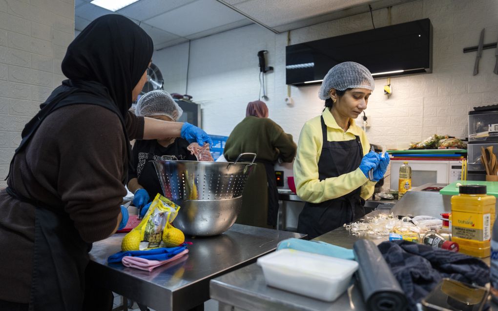 Vrijwilligers koken een maaltijd in de winkel van vrijwilligersorganisatie ”Lichtpuntjes van Mariahoeve”. De organisatie verzamelt geld en spullen voor de slachtoffers van de explosies en brand aan de Tarwekamp in Den Haag. beeld ANP, Jeroen Jumelet