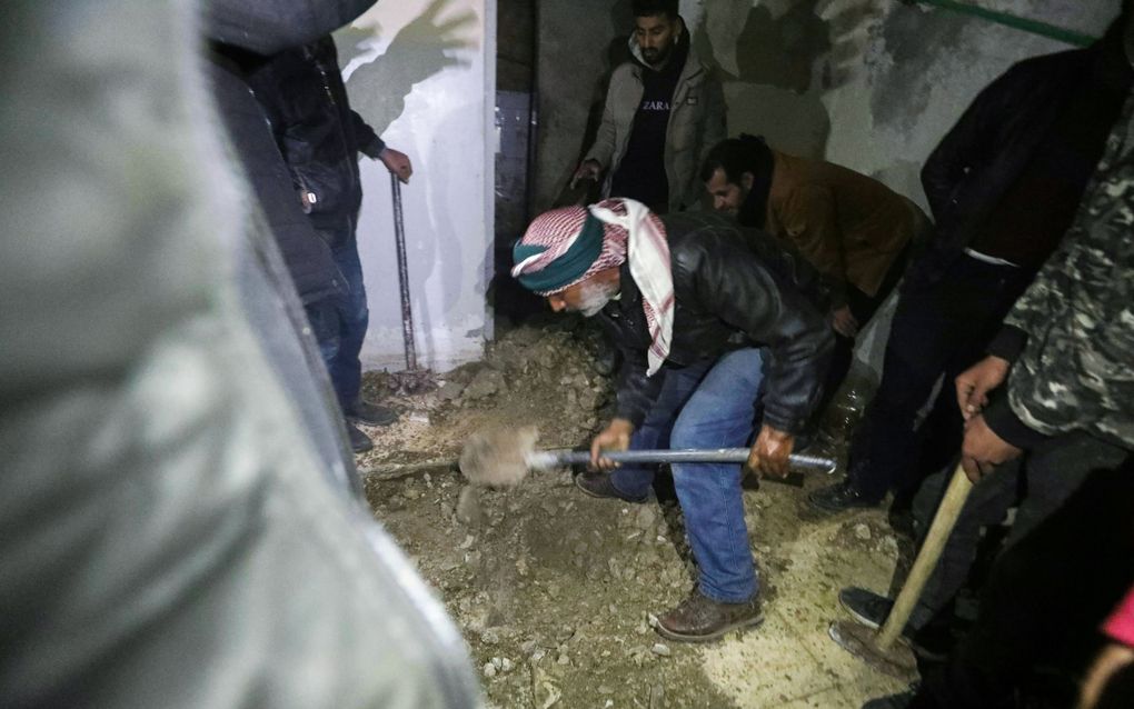 Syrische reddingswerkers zoeken naar mogelijke verborgen kelders in de beruchte Sednay-gevangenis in Damascus op 9 december 2024. beeld AFP, Abdulaziz Ketaz