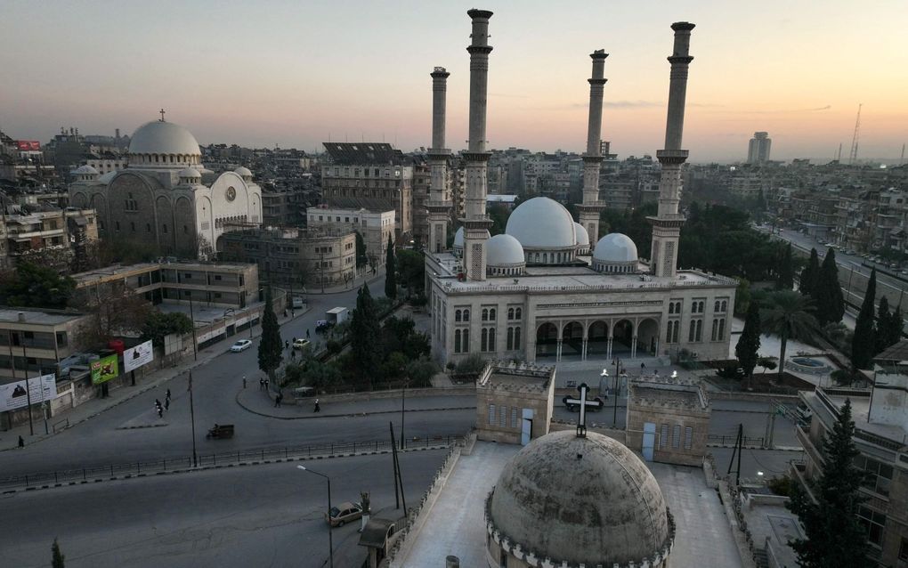 De al-Tawheedmoskee in Aleppo wordt omringd door twee kerken: de Grieks-katholieke kathedraal (l.) en de Chaldeeuwse kerk (onder). beeld AFP, Omar Haj Kadour