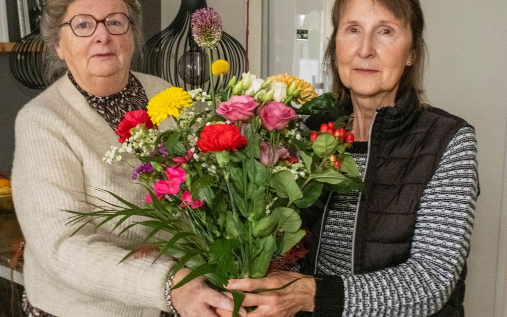 Rita Schilperoort (l.) geeft Betsie de Boer een bloemetje. „Het maakt niet uit waar ze is, maar Betsie denkt altijd aan anderen.” beeld Dirk-Jan Gjeltema