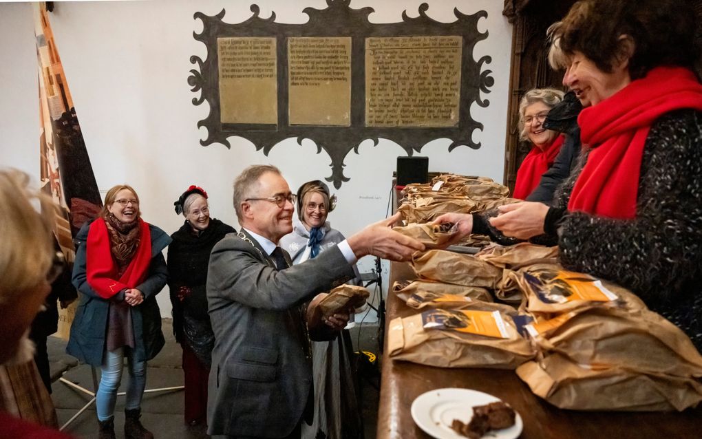 Burgemeester Jos Wienen neemt een „diakenbrood” in ontvangst. beeld Ruben Schipper Fotografie