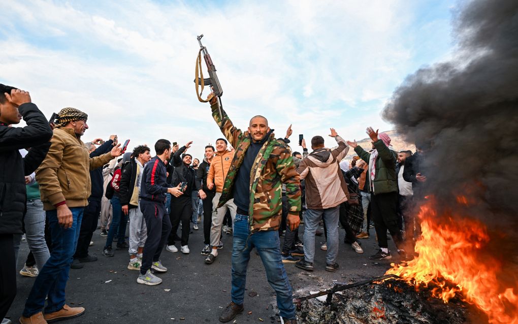 Mensen vieren feest op het Umayyadplein in Damascus na de val van Bashar al-Assad. beeld AFP, Louai Beshara