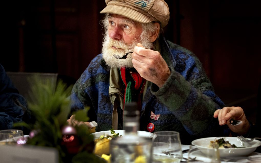 Een gast tijdens een kerstdiner van het Leger des Heils in de Koepelkerk in Amsterdam. Het Leger des Heils houdt kerstvieringen voor ruim vijfhonderd eenzame en kwetsbare Amsterdammers.  beeld ANP, Koen van Weel