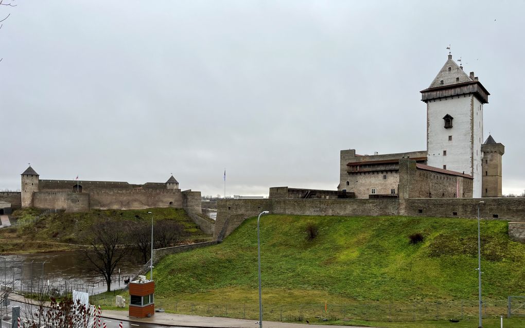 De burcht van de Russische stad Ivangorod (links) en de dertiende-eeuwse Hermansburcht (rechts) van de Estse stad Narva staan nog geen 50 meter uit elkaar verwijderd. Naar de overkant gaan is sinds 24 februari 2022 alleen nog lopend mogelijk. Op de voorgrond is de grensovergang zichtbaar. beeld RD