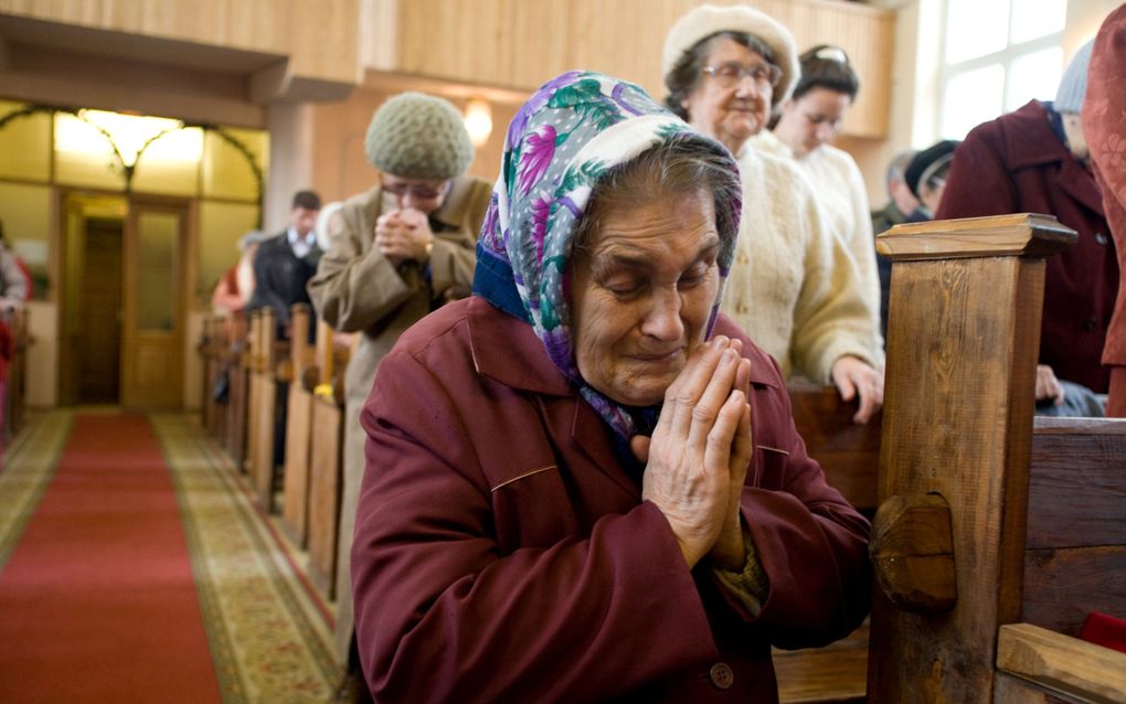 Gebed in een kerkdienst in een Russische baptistenkerk. beeld IMB, Cat Norman