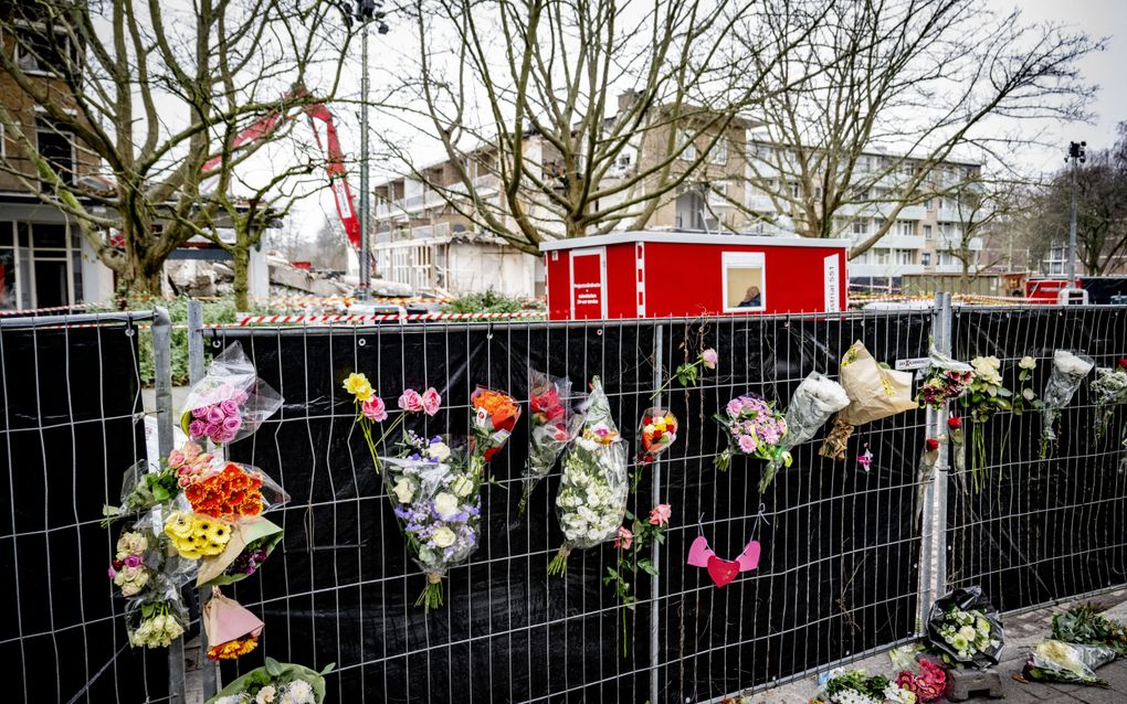 Bloemen hangen aan de hekken bij de Tarwekamp in Den Haag. Een serie explosies op de vroege morgen van 7 december kosten zes mensen het leven. beeld ANP, Robin Utrecht