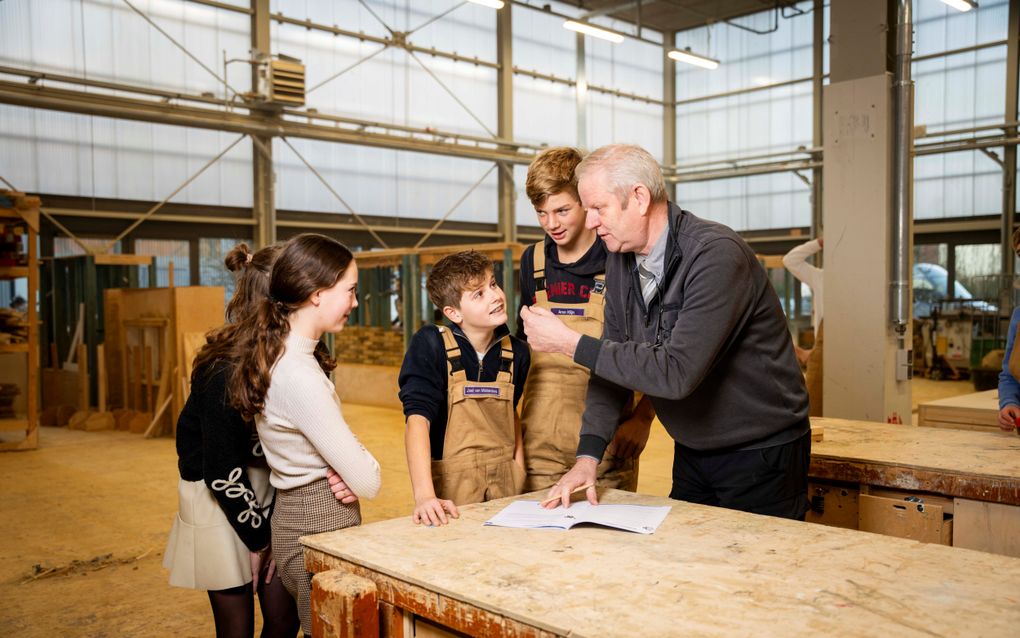 Otto Buitendijk met een paar leerlingen in de werkplaats van de Gomarus scholengemeenschap. beeld Cees van der Wal