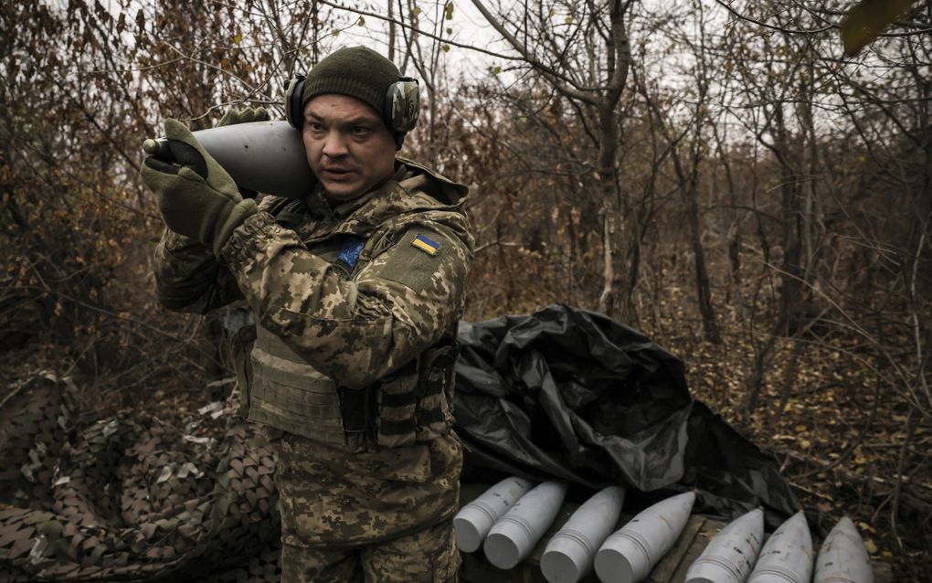 Een Oekraïense militair draagt een granaat in de buurt van Tsjasiv Jar in de regio Donetsk. beeld EPA 