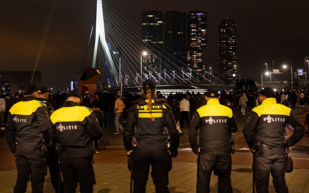 Politieagenten kijken bij de Erasmusbrug in Rotterdam toe bij een eindejaarsshow. beeld ANP, Iris van den Broek