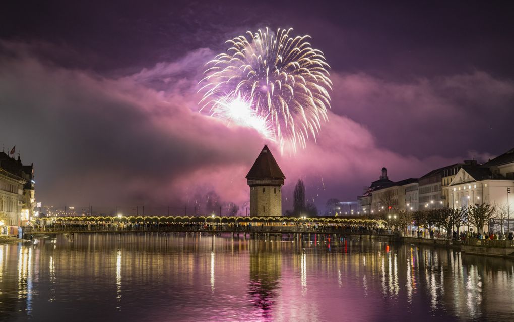 Het nieuwjaarsvuurwerk ontploft boven de Kapelbrug en de oude binnenstad van Luzern, Zwitserland. beeld EPA, Urs Flueeler