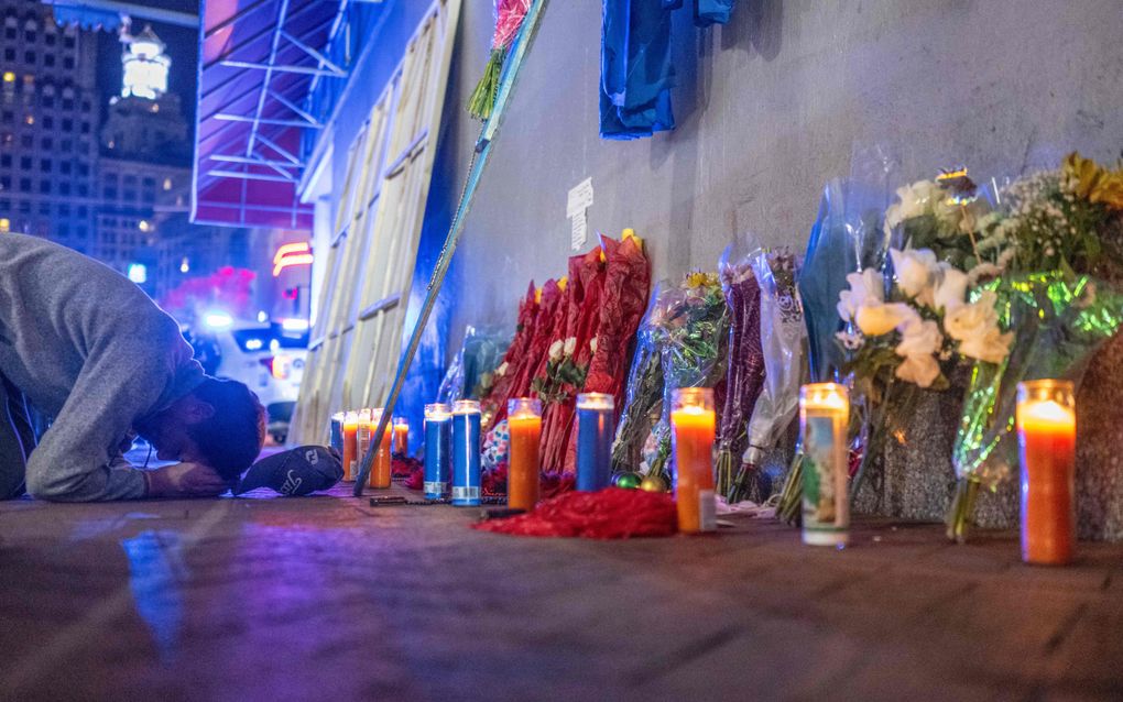 Een man bidt op de herdenkingsplek voor de vijftien mensen die op nieuwjaarsdag om het leven kwamen bij een terroristische aanval met een pick-uptruck die op een menigte feestvierders inreed in Bourbon Street in de Amerikaanse stad New Orleans. beeld AFP, Andrew Caballero-Reynolds