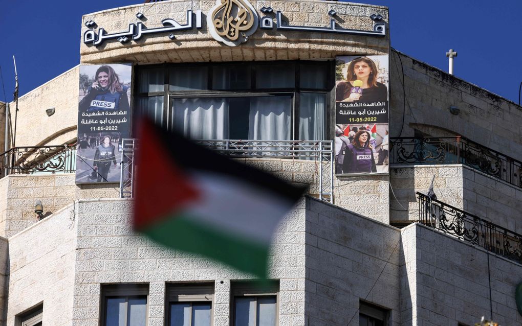 Foto’s van de gedode Palestijnse journaliste Shireen Abu Akleh hangen op de gevel van het gebouw in Ramallah op de Westelijke Jordaanoever waarin Al Jazeera is gehuisvest. De Palestijnse Autoriteit beschuldigt de Arabische zender van opruiing en heeft uitzendingen opgeschort. beeld AFP, Jaafar Ashtiyeh