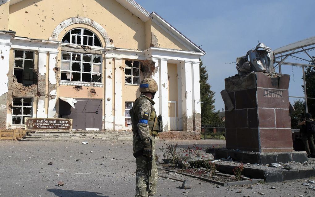 Een Oekraïense militair staat in de zomer voor een vernield gebouw in Soedzja in de door Oekraïne bezette Russische regio Koersk. beeld EPA