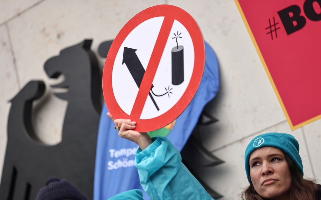 Een vrouw demonstreert voor het gebouw van het ministerie van Binnenlandse Zaken in Berlijn voor een verbod op het gebruik van particulier vuurwerk. beeld EPA, Hannibal Hanschke