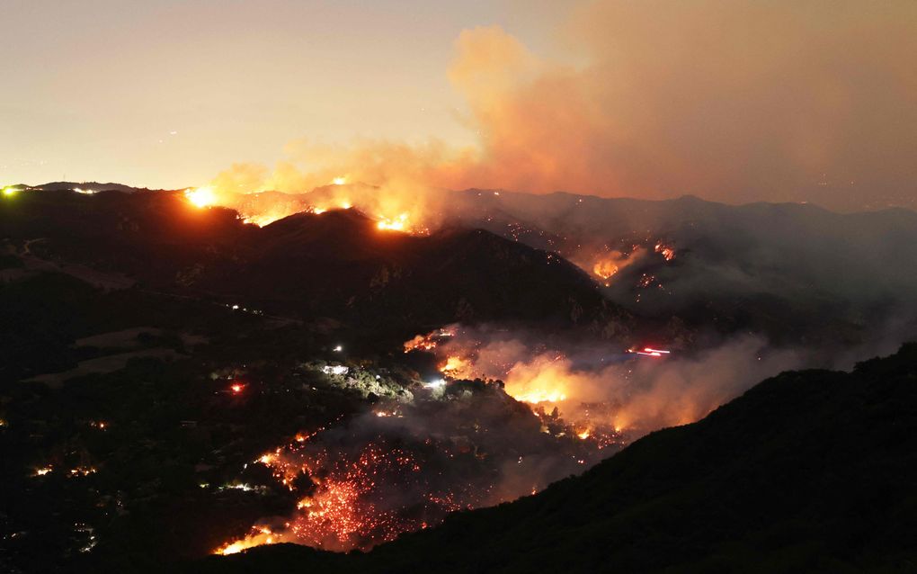 Vlammen en rook omringen de gemeenschap Topanga. beeld AFP, David Swanson