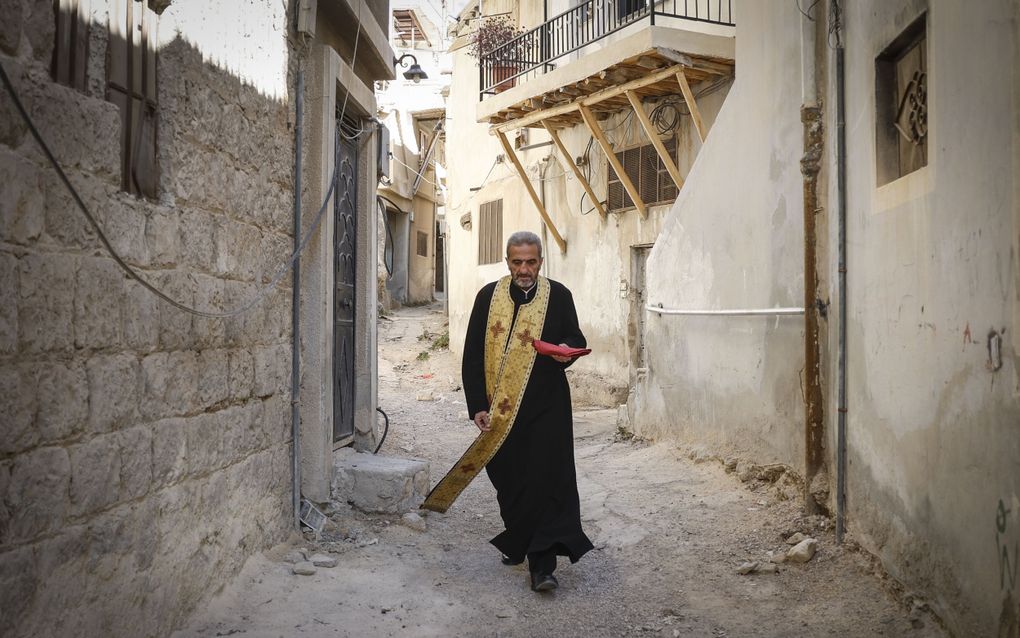 Een priester in een van de straten van Maaloula. beeld EPA, Antonio Pedro Santos