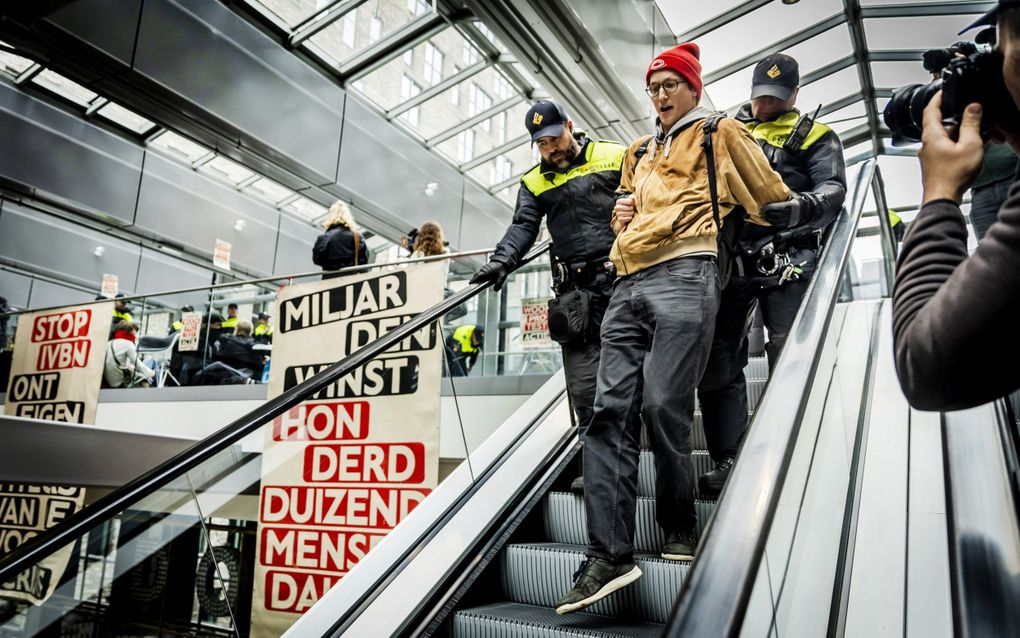 Agenten pakken een demonstrant op tijdens de bezetting van de lobby van het World Trade Centre (WTC) in oktober 2023. De actievoerders willen dat de overheid ingrijpt op de woningmarkt en maatregelen neemt voor meer betaalbare woningen. beeld ANP, Remko de Waal