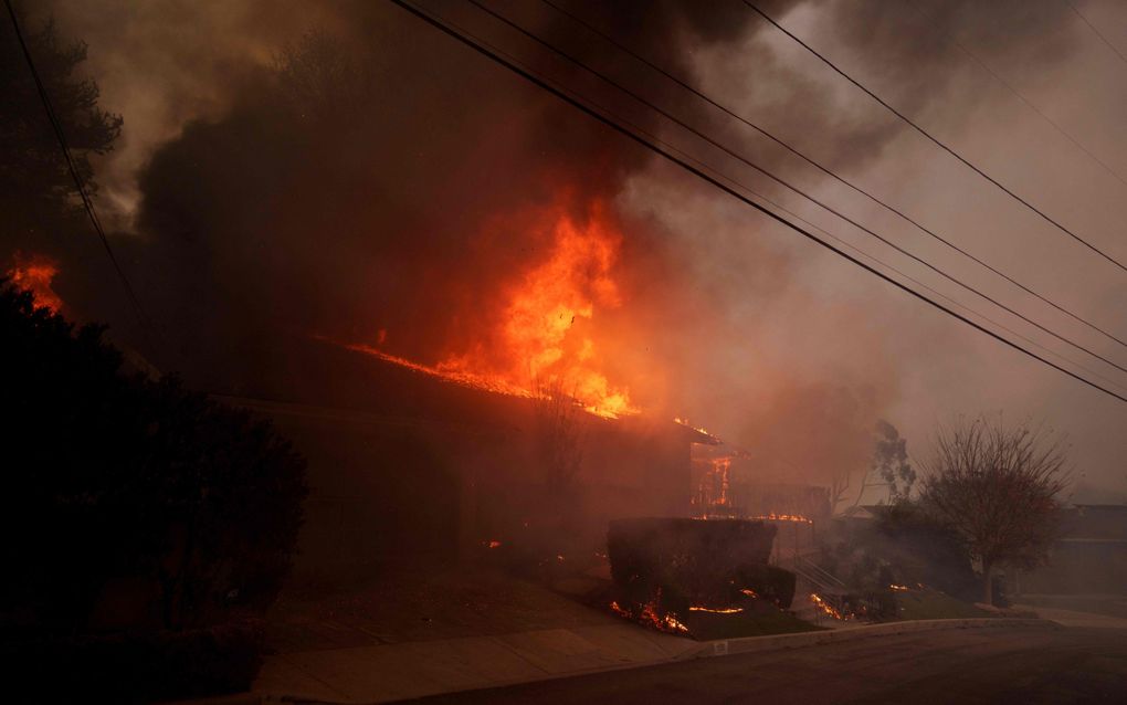 Een huis in Pacific Palisades wordt verzwolgen door de vlammen. Veel verzekeringsmaatschappijen wilden al geen woningen meer verzekeren uit vrees voor verwoestende branden. beeld AFP, Eric Thayer