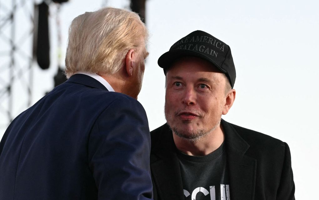 Elon Musk (rechts) op het podium met aankomend president Trump, tijdens een campagnebijeenkomst. beeld AFP, Jim Watson