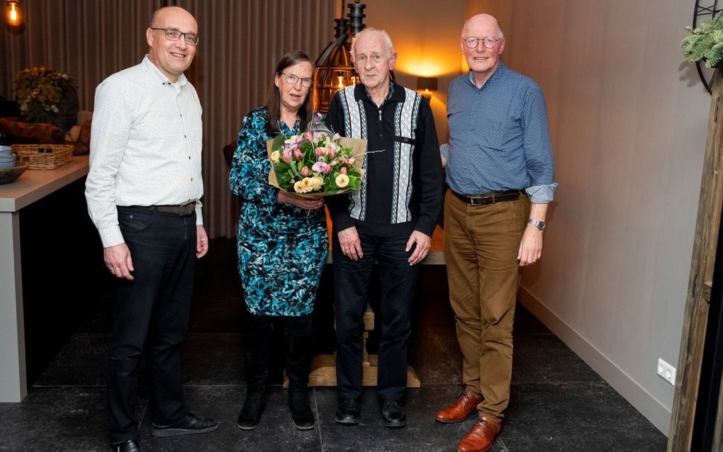 Theo Schumacher (l.) en Henk Zoeteman (r.) geven een bloemetje aan het echtpaar Los-van ‘t Zelfde om hen te bedanken voor hun inzet voor het comité van Woord & Daad in Zwijndrecht en Hendrik-Ido-Ambacht. beeld Cees van der Wal