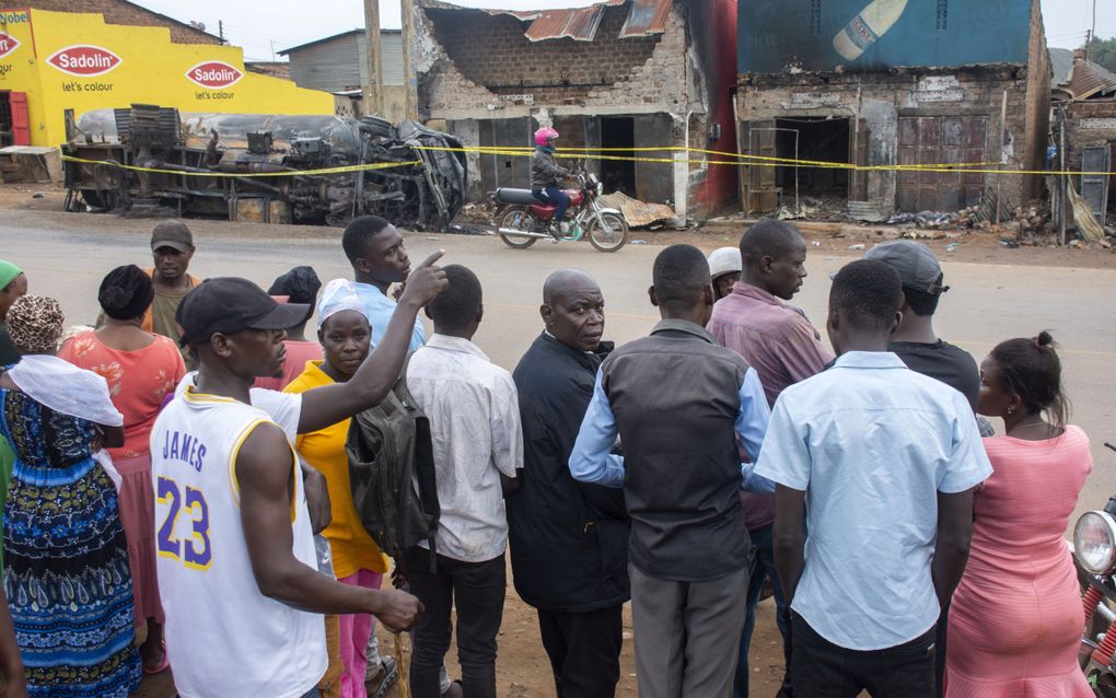 Mensen kijken naar de overblijfselen van een geëxplodeerde brandstoftanker in Uganda. Uganda is een van de landen waar Red een Kind een sponsorprogramma heeft. beeld EPA