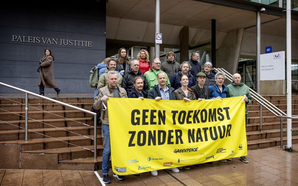 Directeur Andy Palmen (m.) van Greenpeace met een groep medestanders voor de deur van de rechtbank. beeld ANP, Koen van Weel