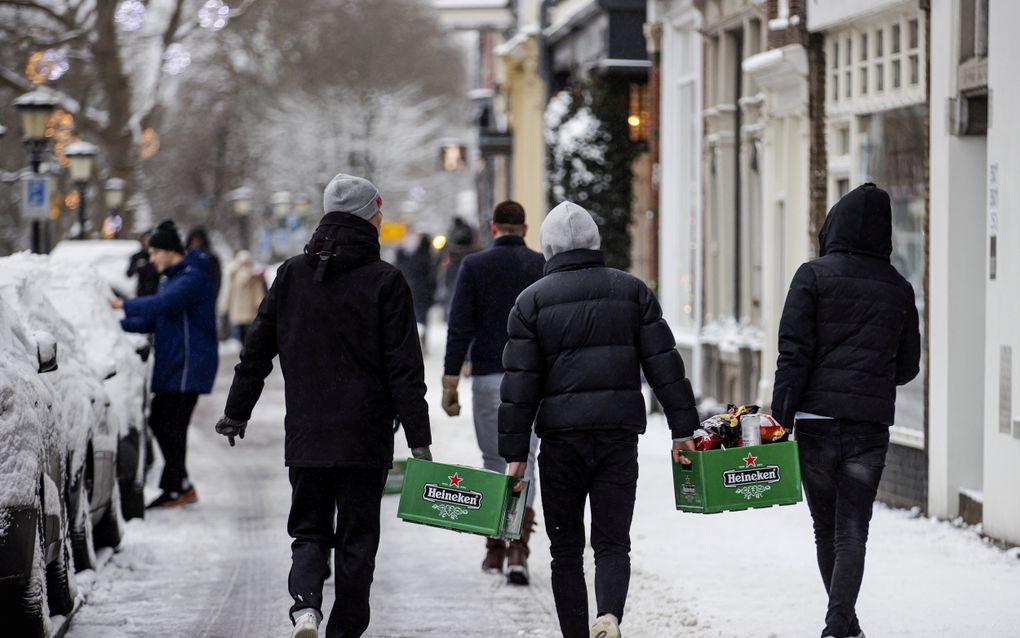 Hoe later jongeren beginnen met het drinken van alcohol, hoe kleiner het risico op verslaving later in hun leven. Foto: jongeren sjouwen in Utrecht met kratten bier. beeld ANP, Robin van Lonkhuijsen